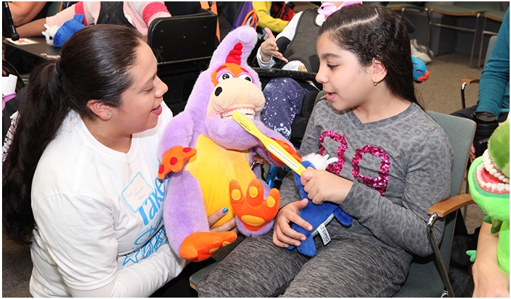 Registered dental hygienist Yocelyn Arevalo educates Henry Viscardi School student Jana during Project Accessible Oral Health's inaugural “Take a Dental Health Day—Screening and Education for the Disability Community” on October 26, 2018, at the Viscardi Center’s campus in Albertson, New York. More than 200 children, teens, and adults with disabilities were educated about the importance of oral healthcare and its impact on overall health. Photo by the Viscardi Center