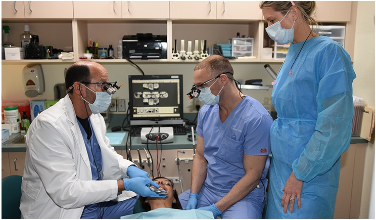 Dr. Steve Barrett (left) works chairside with younger dentists at Greenberg Dental & Orthodontics practices throughout Florida.
