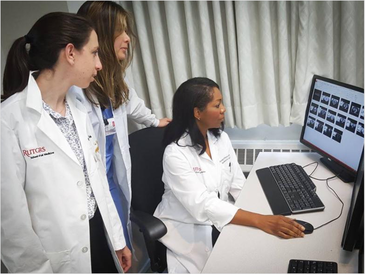 Dr. Maxine Strickland, seated, and students examine radiographs. Photo by Thomas Viccaro.