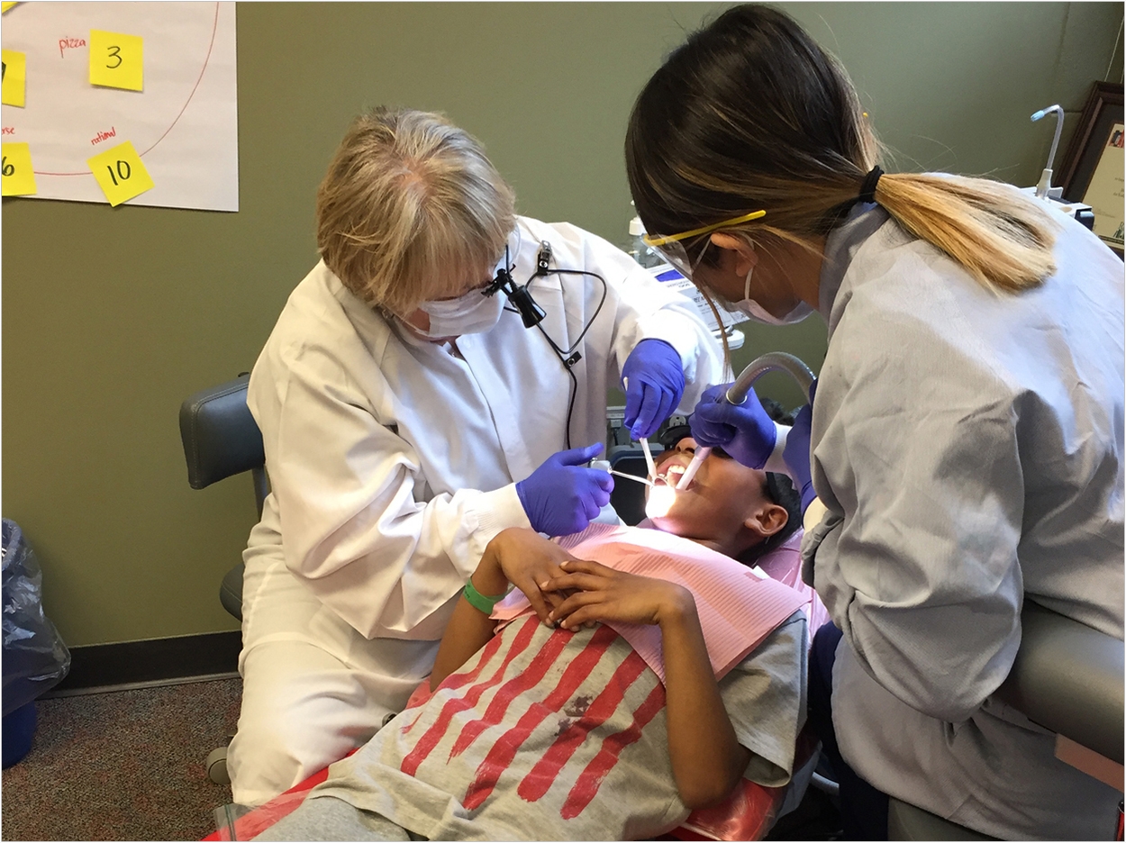 Community Dental Care in Maplewood, Minnesota, applies sealant to a young boy’s molar at his school with resources provided by America’s ToothFairy.
