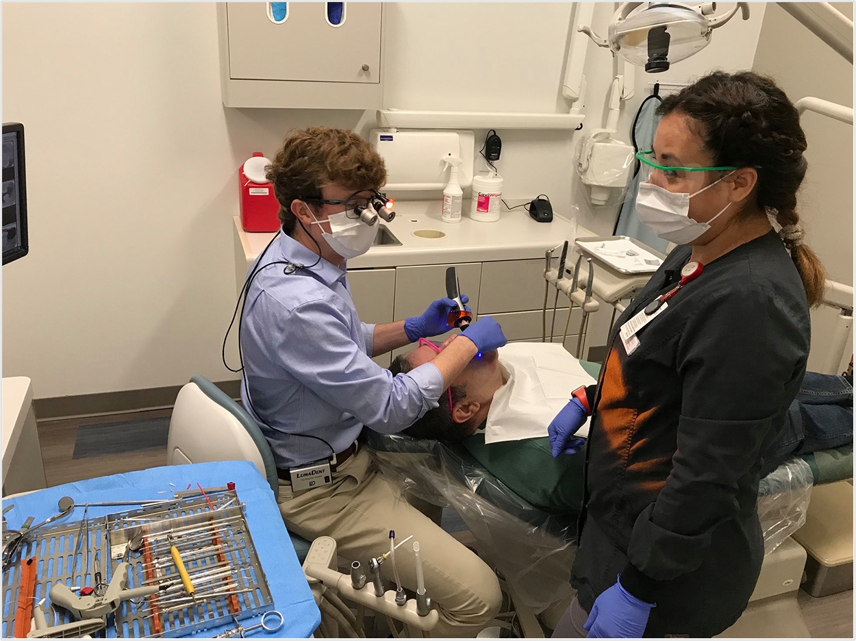 Interfaith Dental Clinic volunteer Dr. Russell Mack, assisted by staff RDA Paola.