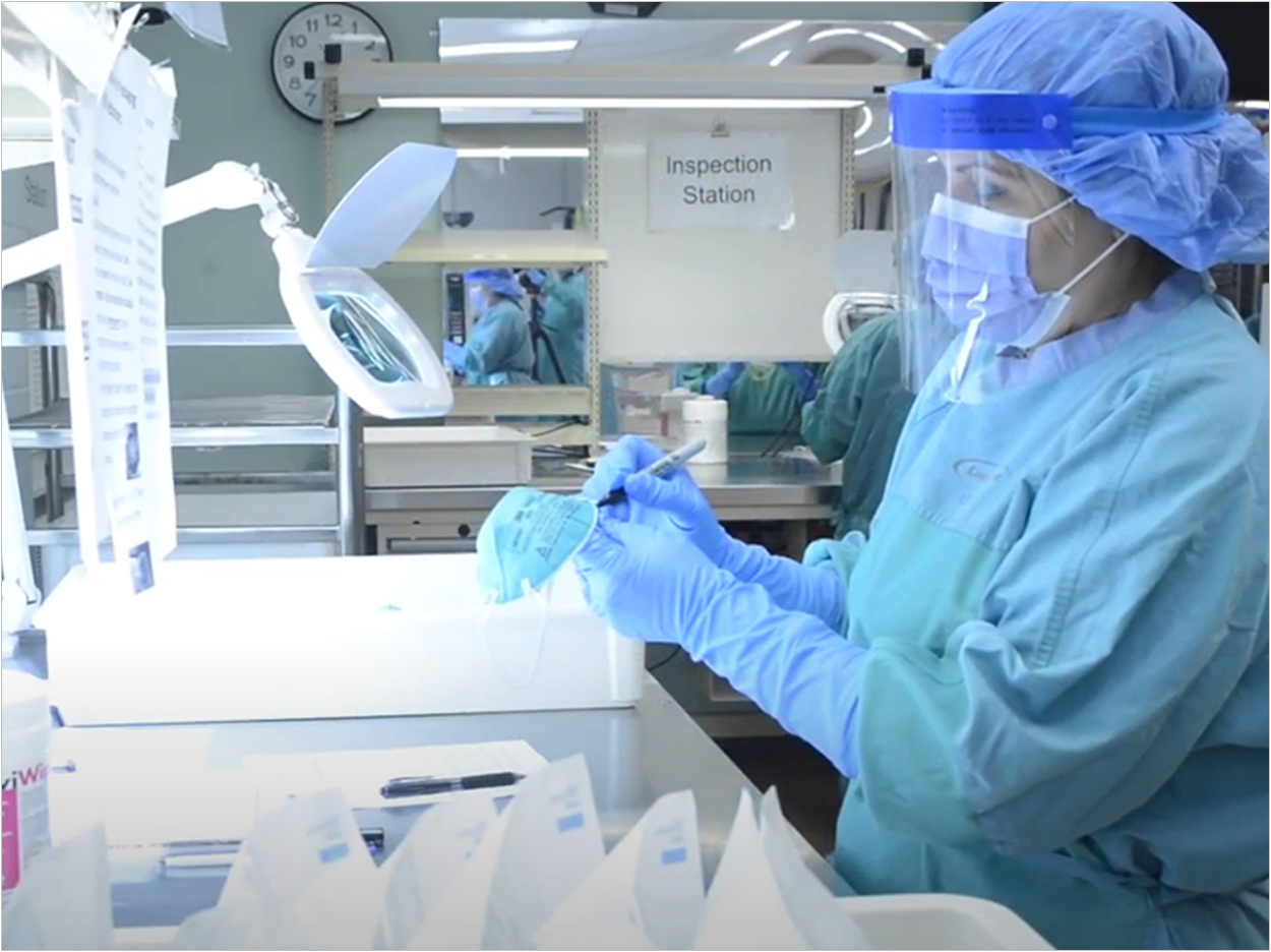 A member of UHN’s Medical Devices Reprocessing Department marks the elastic strap to indicate the respirator will be reprocessed. Photo by UHN