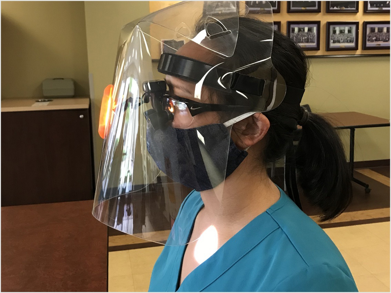 Regular face shields often don't provide enough room for magnification glasses and headlamps dentists need to wear when working with patients. The modified shields from Good Work Society are made with extra room for that equipment. Courtesy of Richard Archer