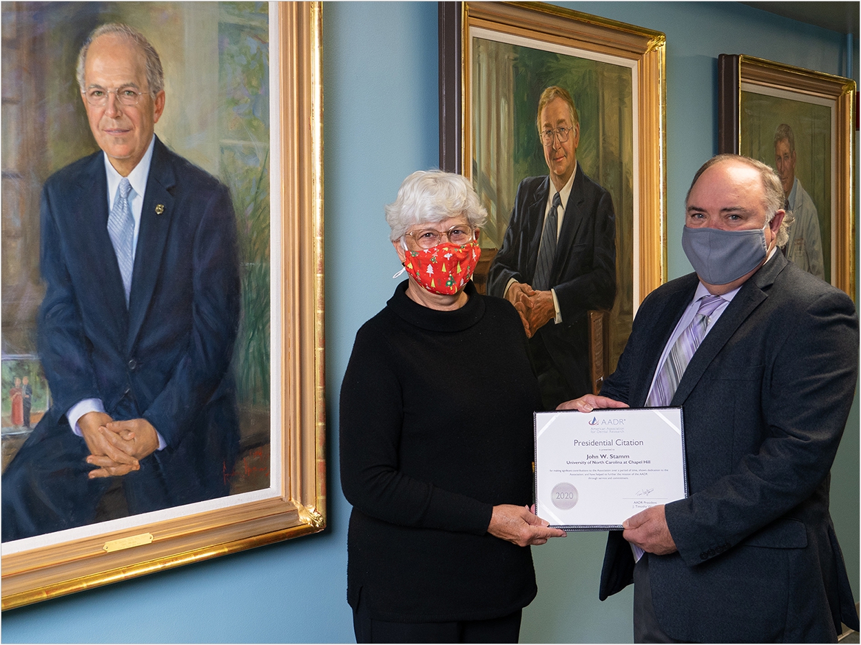 Pictured: Dr. Tim Wright presents Dr. Carol Stamm with the AADR Presidential Citation Award in honor of her husband, Dr. John Stamm.