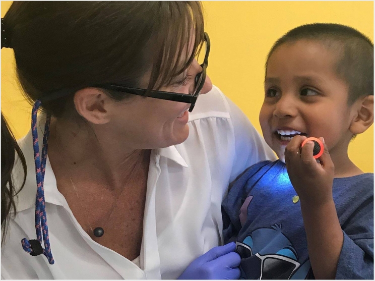 Dr. Gretchen Henson, a pediatric dentist with Neighborhood Outreach Access to Health (NOAH) in Scottsdale visits with a young patient after an SDF application. NOAH is a recipient of grant funding from the Delta Dental of Arizona Foundation. Photo by Neighborhood Outreach Access to Health (NOAH).