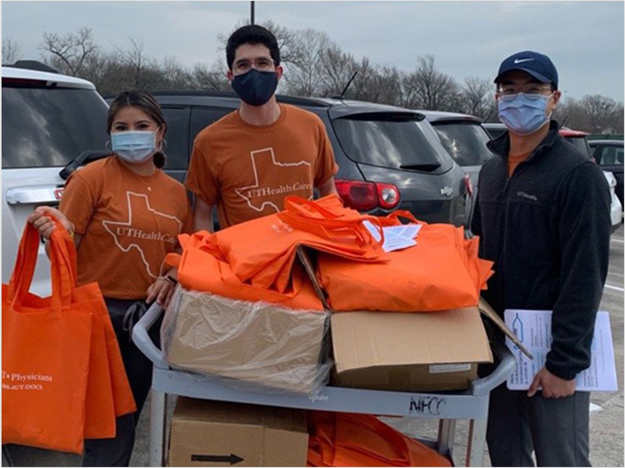 UTSD volunteers (from left) Anissa Rodriguez, Diego Rivas, and Thanh Le help distribute care packages and vaccine registration forms.